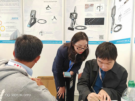 亚泰光电展台前,公司内窥镜工程师与客户亲密交谈为